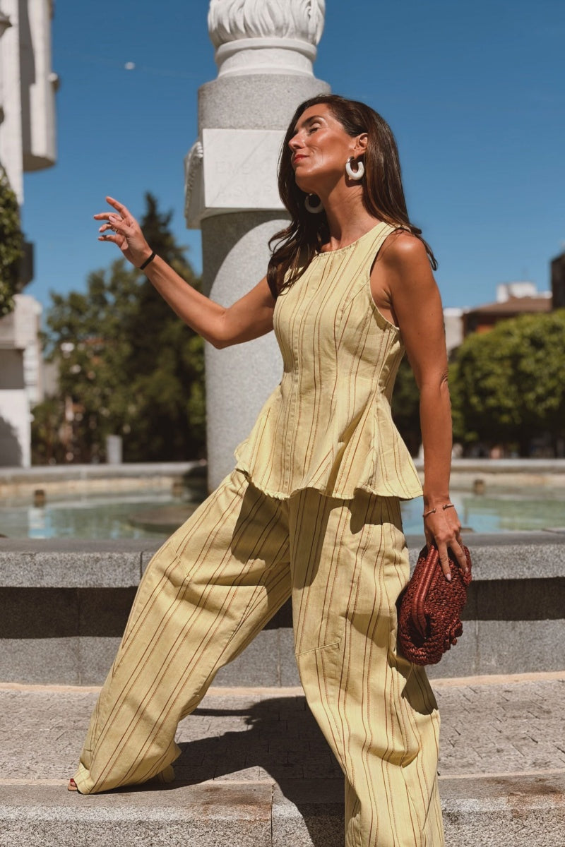 Completo con top peplum a righe gialle e pantaloni a gamba larga