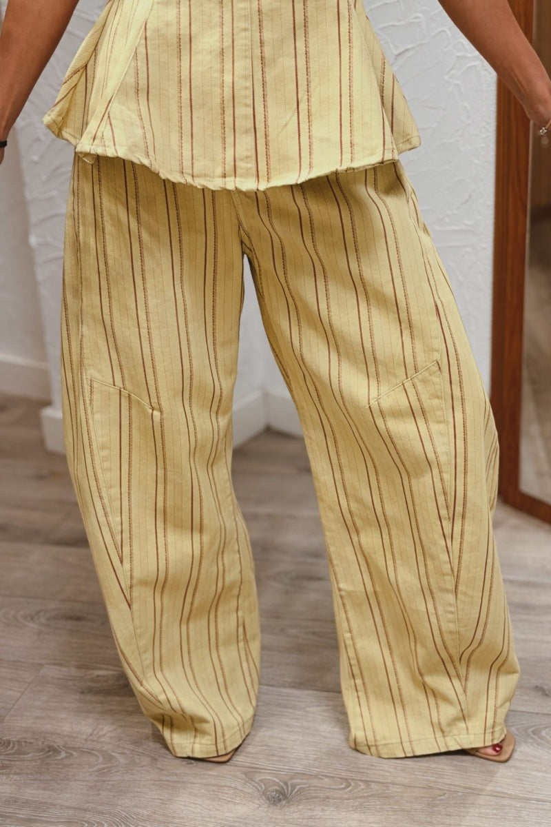 Completo con top peplum a righe gialle e pantaloni a gamba larga